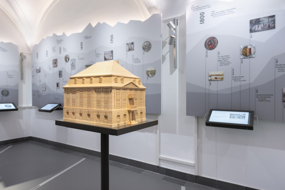 Tastmodell des Zumsteinhauses aus Holz vor Wabd mit Zeitstrahl Stadtgeschichte