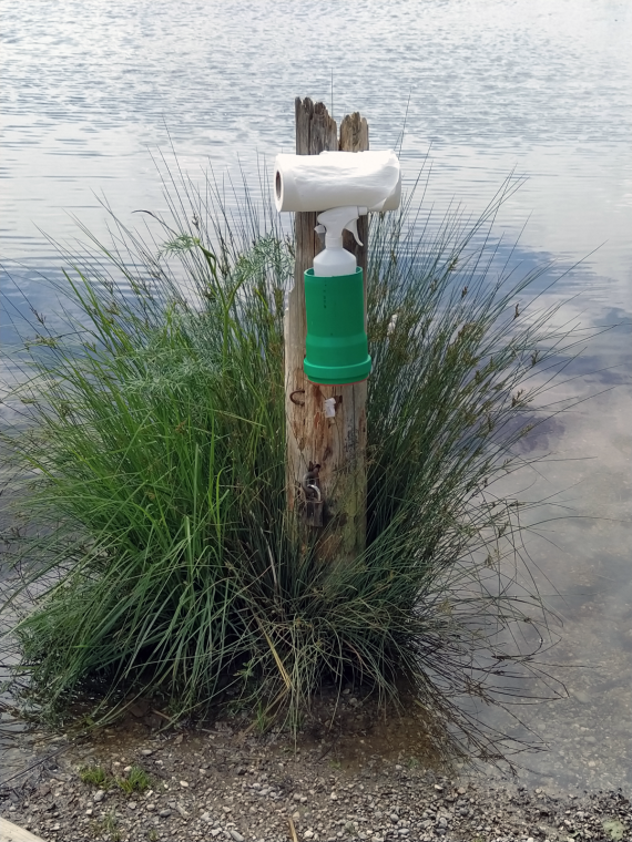 Bootsanlegeplatz am Wasser mit Desinfektionsmittel und Küchenrolle