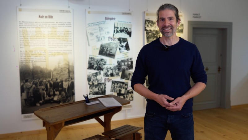 Armin Heigl, Lehrer am Hilde, vor historischer Schulbank