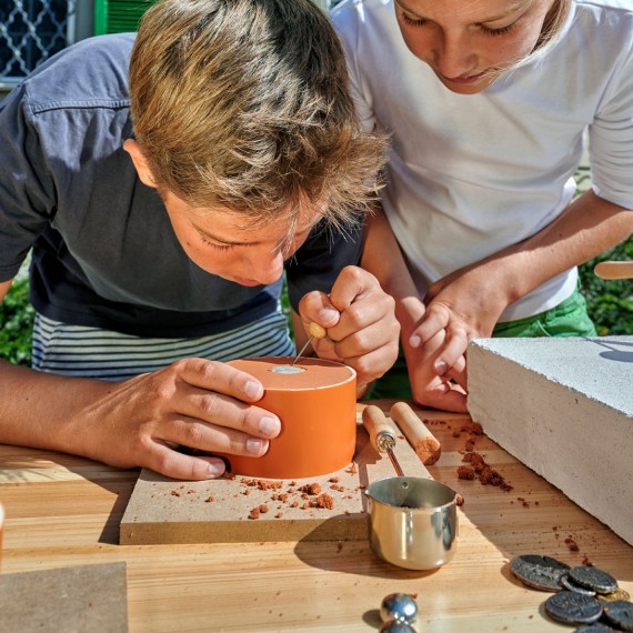 Junge erstellt Abruck von M&uuml;nze