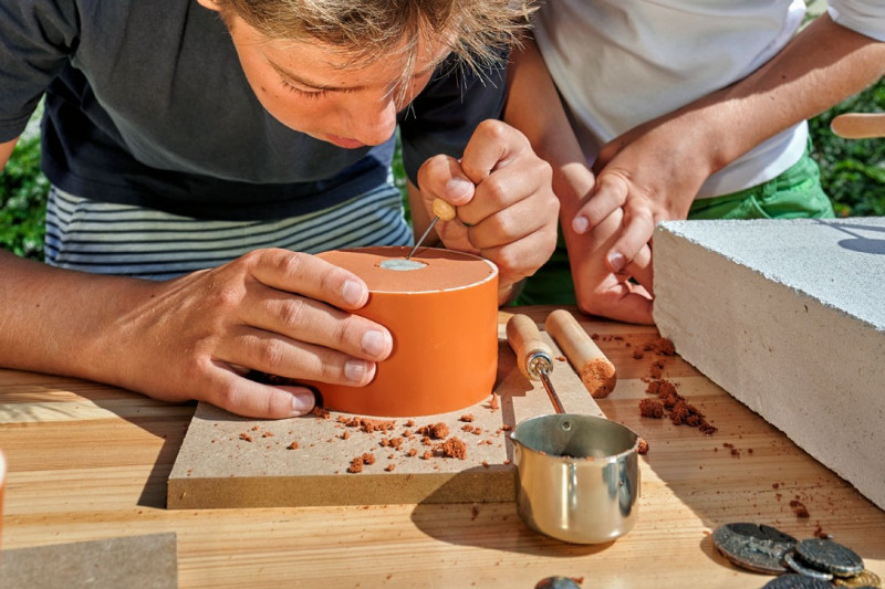 Junge erstellt Abruck von M&uuml;nze