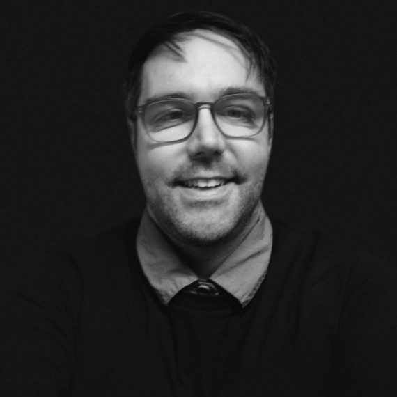 schwarz weißes Bild eines Mannes mit Brille, der lacht