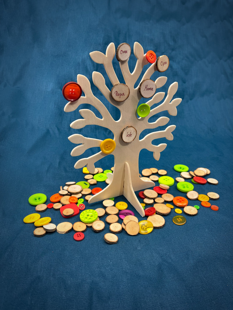 Holzbaum mit bunten Kn&ouml;pfen best&uuml;ckt auf blauem Stoff