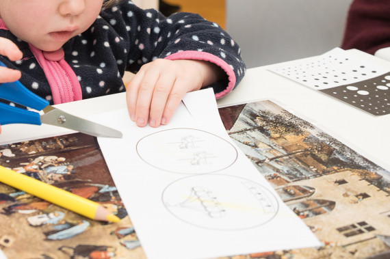 Kleinkind schneidet Kreise aus Papier aus