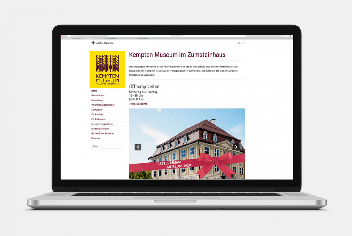Laptop mit geöffneter Startseite www.kempten-museum.de: Links oben in der Ecke ist das Museumslogo, darunter die Navigation, daneben die Öffnungszeiten, ein Begrüßungstext und ein Foto vom Museum