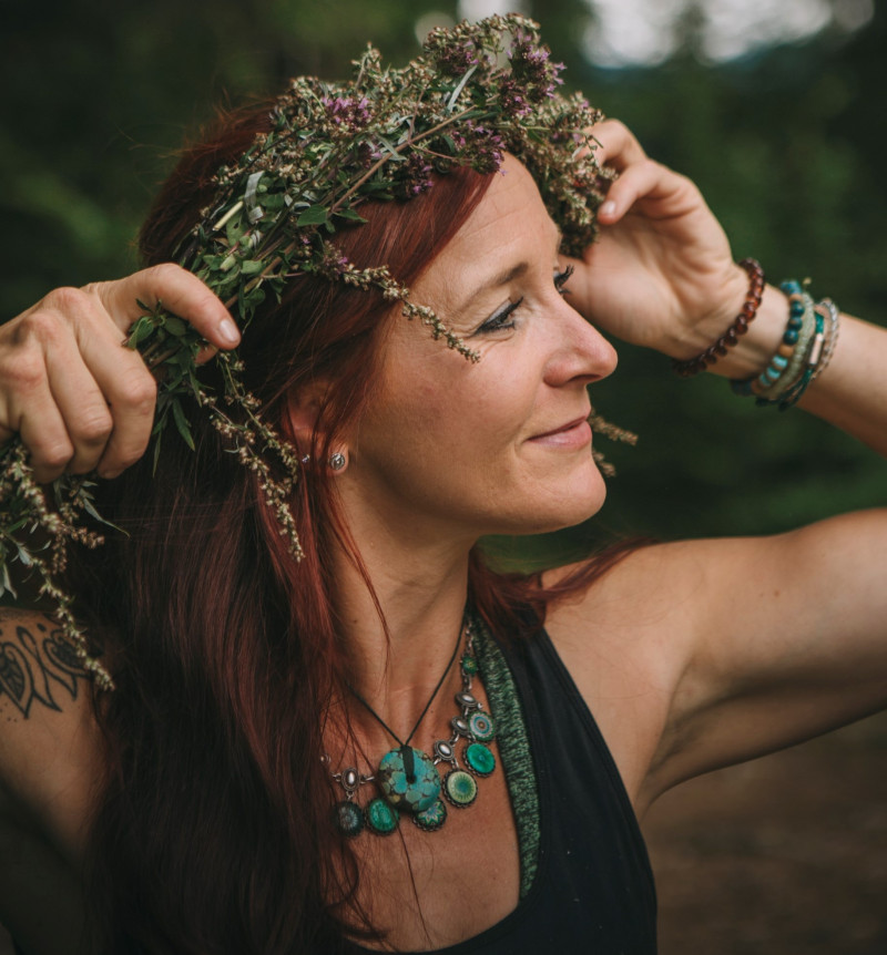 eine l&auml;chelnde Frau zur Seite blickend mit einem Kranz auf dem Kopf