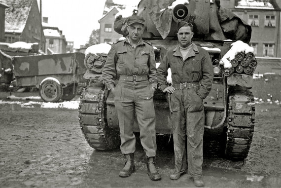 schwarz-weiß Foto mit zwei Soldaten, die vor einem Panzer stehen
