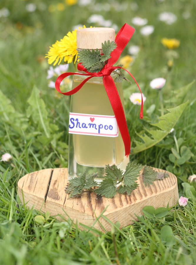 Flasche mit hellgr&uuml;ner Fl&uuml;ssigkeit auf einer bl&uuml;henden Wiese