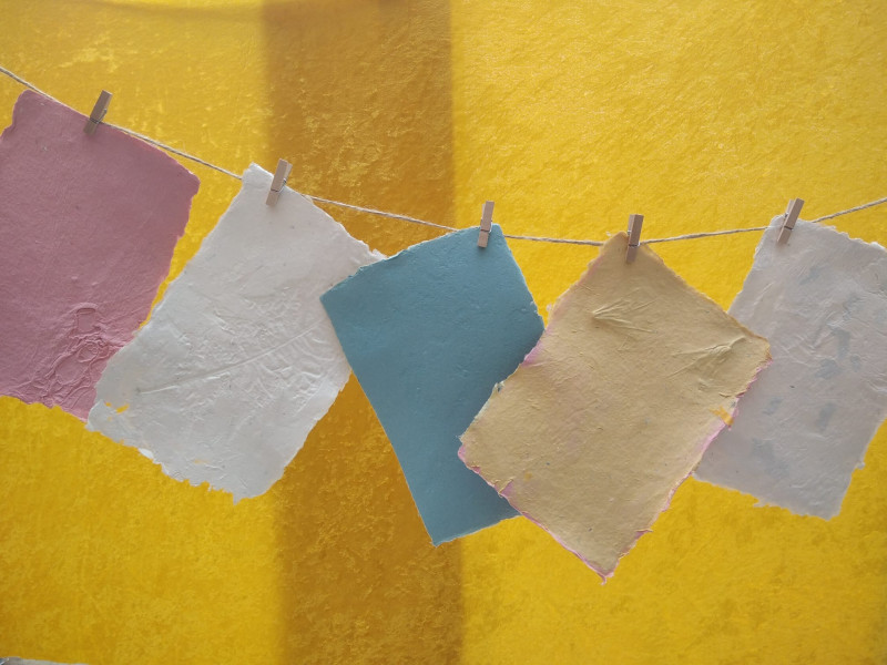 handgeschöpfte bunte Papiere hängen an einer Leine
