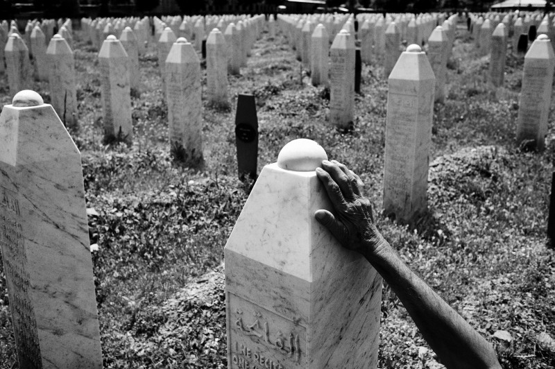 eine Hand ber&uuml;hrt einen Grabstein