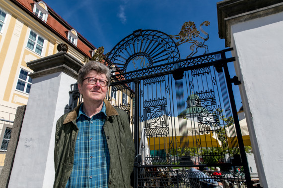 Wolfgang Petz steht am metallenen Tor vor dem Zumsteinhaus